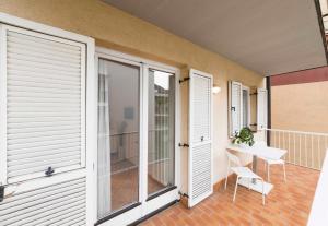 balkon z białymi drzwiami oraz stołem i krzesłem w obiekcie Pixner Apartments w mieście Bolzano