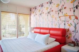 a red bed in a room with a flowery wall at Austin Motel in Austin