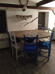 une table à manger avec des chaises bleues et une table en bois dans l'établissement Apartmány Javorek, à Sněžné