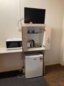 a small refrigerator with a tv on top of it at Wattle Tree Motel in Cootamundra