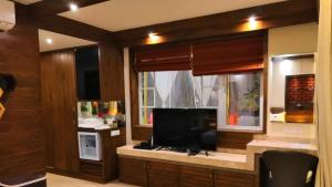 een woonkamer met een televisie en een raam bij Shivers Oasis Luxury Boutique Resort in Candolim
