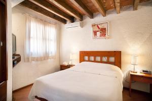 a bedroom with a white bed and a window at Villas Casa Divina At San Felipe Church Area in Oaxaca City