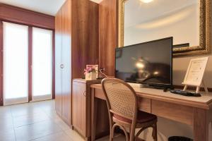 Televízia a/alebo spoločenská miestnosť v ubytovaní Albergo Villa Priula