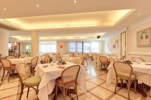 um salão de banquetes com mesas e cadeiras com toalha de mesa branca em Albergo Villa Priula em Sorisole