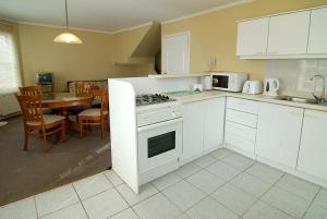 a kitchen with a stove and a dining room with a table at Apart Hotel Casablanca in Valdivia