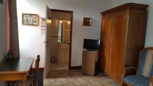a living room with a table and a television and a door at La Closeraie in Champagné-les-Marais