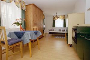 a kitchen and dining room with a table and a bedroom at Haus Lenz Ferienwohnungen - Fam Ostermann in Puchberg am Schneeberg