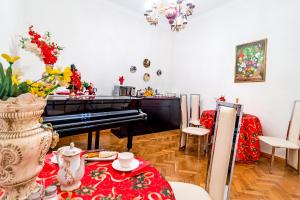 a living room with a piano and a table at V Park Hotel in Tbilisi City