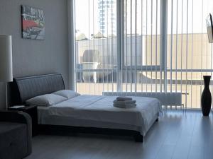 ein Schlafzimmer mit einem Bett und einem großen Fenster in der Unterkunft Apartmant in Smart Plaza in Kiew