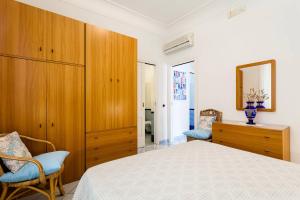 Schlafzimmer mit einem Bett und einem Holzschrank in der Unterkunft Casa Dorothea 1 in Positano