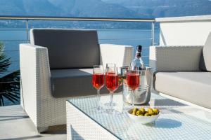a table with two glasses of wine and a bowl of fruit at Villa Poseidon in Porto Valtravaglia