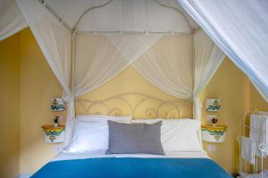 1 dormitorio con cama con dosel y almohadas blancas en Regina Elena, en Nápoles