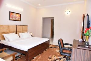 um quarto com uma cama, uma secretária e uma cadeira em Arkaya Inn em Gurgaon