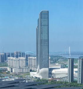 ein hohes Gebäude in einer Stadt mit einem großen Gebäude in der Unterkunft Jumeirah Nanjing in Nanjing