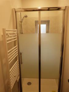 La salle de bains est pourvue d'une douche avec une porte en verre. dans l'établissement Le Petit Herbauges, à Bouaye