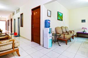 a living room with a refrigerator and chairs at Casa Sidoluhur 17 in Surabaya