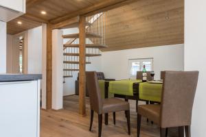 a dining room with a green table and chairs at Haus Bergsonne in Saas-Almagell