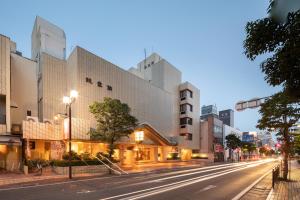 una via cittadina di notte con un edificio di Hotel Danrokan a Kōfu