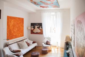 ein Wohnzimmer mit einem Sofa und einem Gemälde an der Decke in der Unterkunft FL Apartments Casa d'artista in Rom