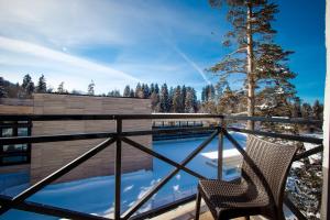 a balcony with a chair and a swimming pool at BM Plaza in Bakuriani