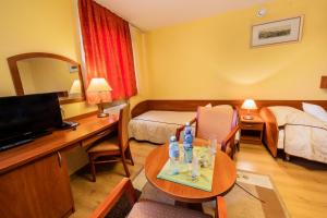 a hotel room with a bed and a table with a television at Hotel Wald in Warsaw