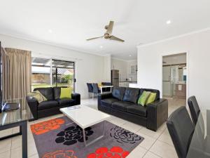 a living room with couches and a table at Riviera Motel Bundaberg in Bundaberg