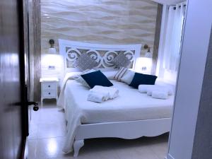 a bedroom with a white bed with blue pillows at Villa Mica in La Maddalena
