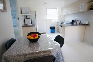 a table in a kitchen with a bowl of fruit on it at Leisure By The Sea in Kleinmond