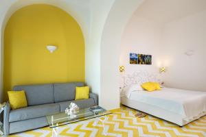 Relais Maresca Luxury Small Hotel & Terrace Restaurant في كابري: غرفة معيشة مع سرير وأريكة
