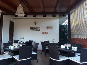 comedor con 2 mesas y sillas en Perla Del Mare Affittacamere, en Campofelice di Roccella