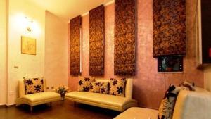 a living room with two chairs and paintings on the wall at Pension Casa Grande in Baile Felix