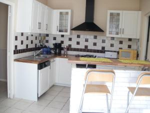 een keuken met witte kasten en een spoelbak bij Vacances a St Germain d Esteuil 33340 in Saint-Germain-dʼEsteuil
