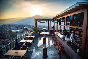 een restaurant met tafels en stoelen op een balkon bij Vivanta Kathmandu in Kathmandu