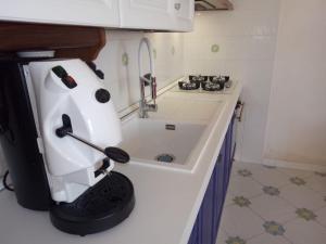 a small kitchen with a white appliance on a counter at Villetta Cala Rotonda in Favignana +20 photos
