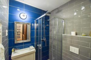 ブダペストにあるBluebel Luxory Apartment in the city centerの青いタイル張りのバスルーム(シンク、鏡付)
