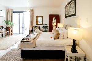 sypialnia z dużym łóżkiem i lampką w obiekcie Radium Hall Guest House w Kapsztadzie