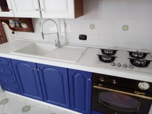 una cucina con armadi blu e lavandino di Villetta Cala Rotonda a Favignana