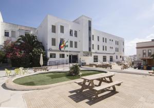 a building with a picnic table and benches in front of it at Albergue Inturjoven Chipiona in Chipiona