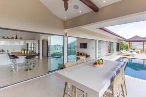 an open kitchen and dining room with a pool and a house at Stunning sea view villa Lamai Koh Samui in Lamai