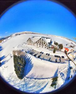 uma vista de um edifício na neve em Alpina Lodge Hotel Oberwiesenthal em Kurort Oberwiesenthal