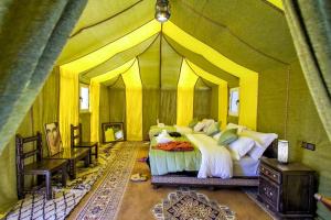 a bedroom with a tent with a bed in it at Sahara Majestic Luxury Camp in Merzouga