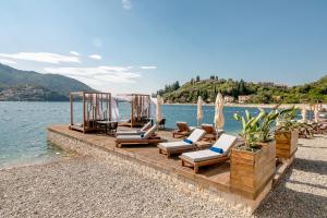 a group of lounge chairs and umbrellas on a beach at Boutique Hotel & Spa Casa del Mare - Mediterraneo in Herceg-Novi