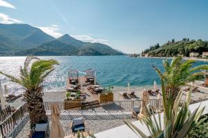 uma vista para um lago com cadeiras e palmeiras em Boutique Hotel & Spa Casa del Mare - Mediterraneo em Herceg Novi