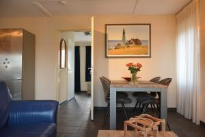 een woonkamer met een tafel en stoelen bij Appartement Derde Zandwijkje in Hollandscheveld