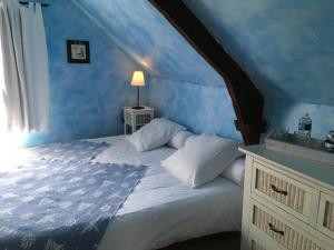 a bedroom with a large bed with blue walls at La Clef du Four in Plesder