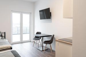 a room with a table and chairs and a window at Monteurzimmer Berlin Pankow mit Dachterrasse - Nur 10 min. von der A10 - 3 Zimmer/ 7 Betten in Berlin