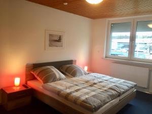 a bedroom with a bed with two lamps and a window at Ferienwohnung im Zentrum in Bad Schwartau