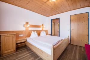 a bedroom with a large bed and a wooden ceiling at Aparthotel Markushof in Wagrain