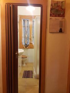 a bathroom with a toilet and a shower and a door at Milhouse in Cagliari
