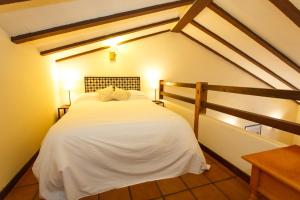 a bedroom with a white bed in a attic at El Bulin de Robregordo in Robregordo